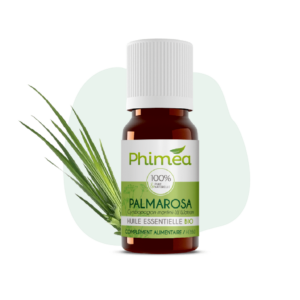 Flacon huile essentielle de palmarosa avec feuilles en arrière plan sur fond vert